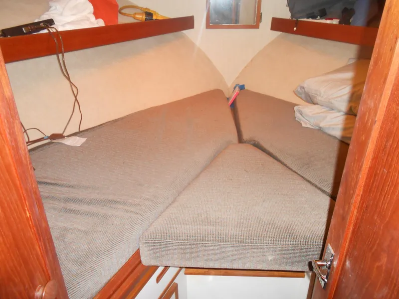 Slide: The Image of 1981 Uniflite Cabin Cruiser interior with V-berth, wooden shelves, and cushions. - 16