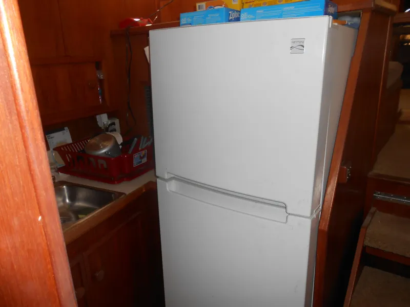 Slide: The Image of 1981 Uniflite Cabin Cruiser kitchen with white refrigerator and sink. - 18