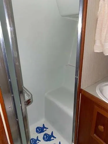 Slide: The Image of 1981 Uniflite Cabin Cruiser shower with fish decals and wooden cabinetry. - 22
