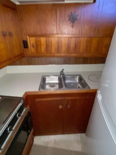 Slide: The Image of 1981 Uniflite Cabin Cruiser kitchen with wood paneling and dual sink. - 25