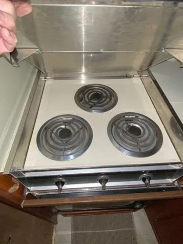 Slide: The Image of 1981 Uniflite Cabin Cruiser stove with three electric burners and metal cover. - 26