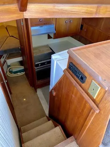Slide: The Image of 1981 Uniflite Cabin Cruiser interior with kitchen and wooden cabinetry. - 27