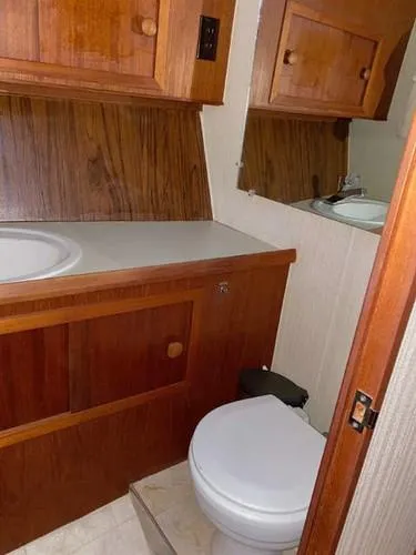 Slide: The Image of 1981 Uniflite Cabin Cruiser bathroom with wooden cabinets and compact design. - 28