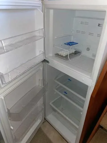 Slide: The Image of 1981 Uniflite Cabin Cruiser refrigerator, open and empty, showing shelves and compartments. - 29