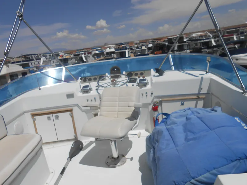 Slide: The Image of 1981 Uniflite Cabin Cruiser helm with seating, steering wheel, and clear sky background. - 3