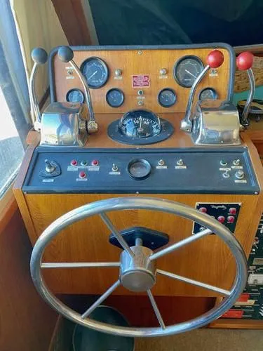 Slide: The Image of 1981 Uniflite Cabin Cruiser helm with steering wheel and control panel. - 33