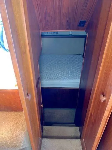 Slide: The Image of 1981 Uniflite Cabin Cruiser interior with wooden paneling and a cozy sleeping area. - 34