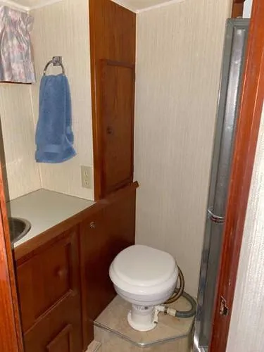 Slide: The Image of 1981 Uniflite Cabin Cruiser bathroom with toilet, sink, and towel. - 35