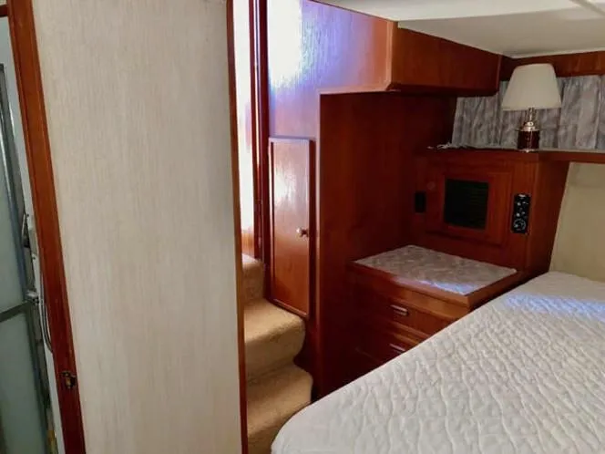 Slide: The Image of 1981 Uniflite Cabin Cruiser interior with wood paneling, stairs, and bed. - 36