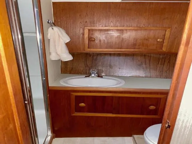 Slide: The Image of 1981 Uniflite Cabin Cruiser bathroom with wooden cabinets and sink. - 42