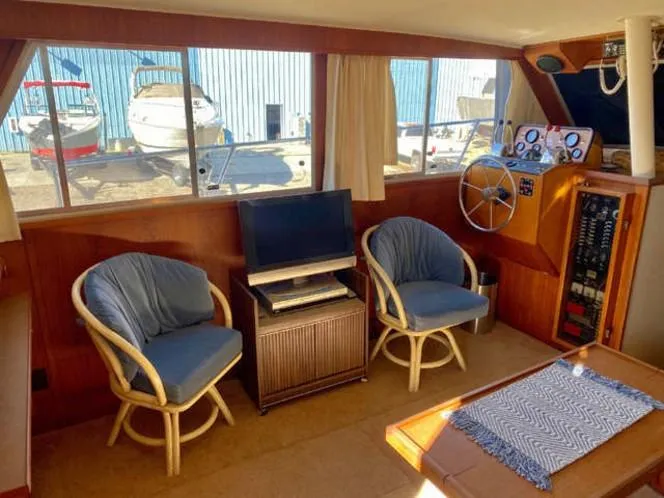 Slide: The Image of 1981 Uniflite Cabin Cruiser interior with chairs, TV, and control panel. - 43