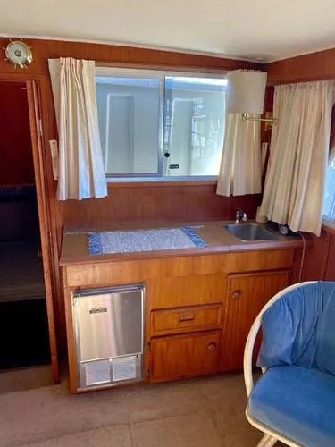 Slide: The Image of 1981 Uniflite Cabin Cruiser interior with kitchenette, sink, and seating area. - 44