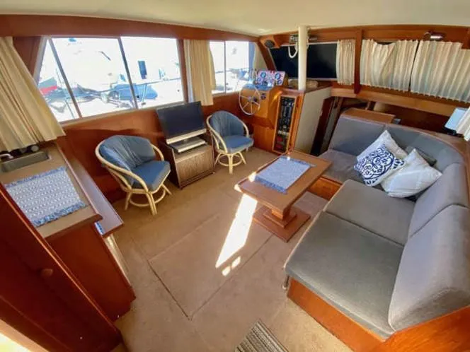 Slide: The Image of 1981 Uniflite Cabin Cruiser interior with cozy seating, wooden accents, and nautical decor. - 46