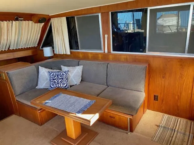 Slide: The Image of 1981 Uniflite Cabin Cruiser interior with cozy seating, wooden table, and nautical decor. - 47