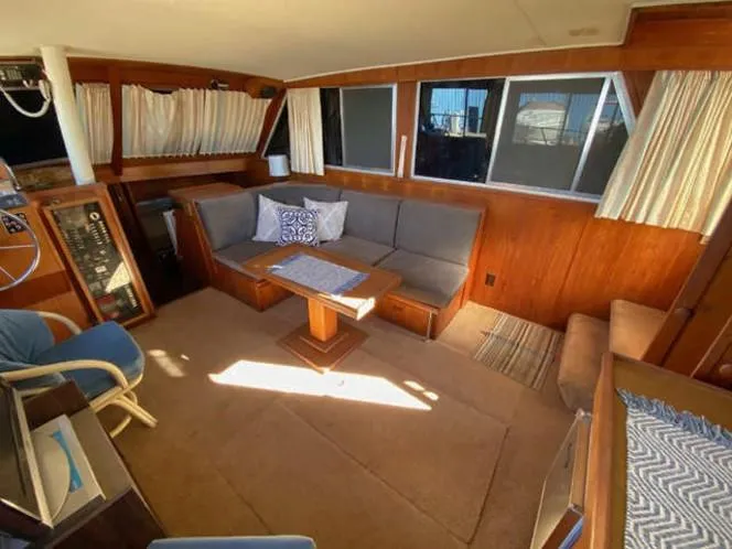Slide: The Image of 1981 Uniflite Cabin Cruiser interior with cozy seating and wooden accents. - 48
