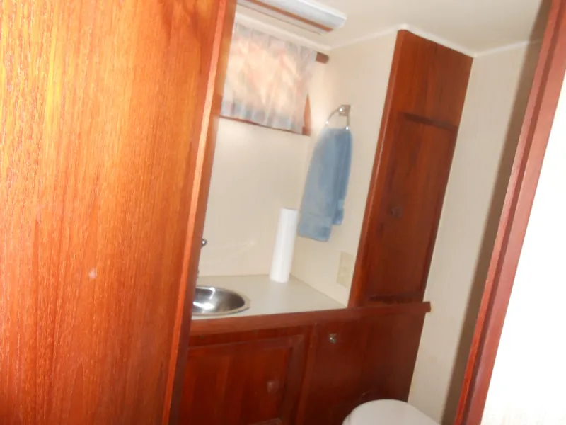 Slide: The Image of 1981 Uniflite Cabin Cruiser bathroom with wooden cabinets and stainless steel sink. - 7