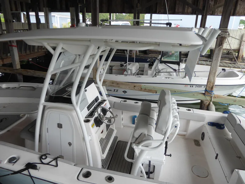 Slide: The Image of 2022 Sea Fox 248 Commander boat docked, featuring a sleek console and seating. - 3