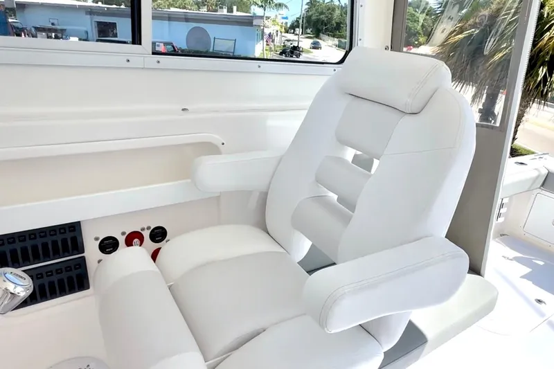 Slide: The Image of 2024 NorthCoast 255HT boat interior with luxurious white captain's chair and control panel. - 15