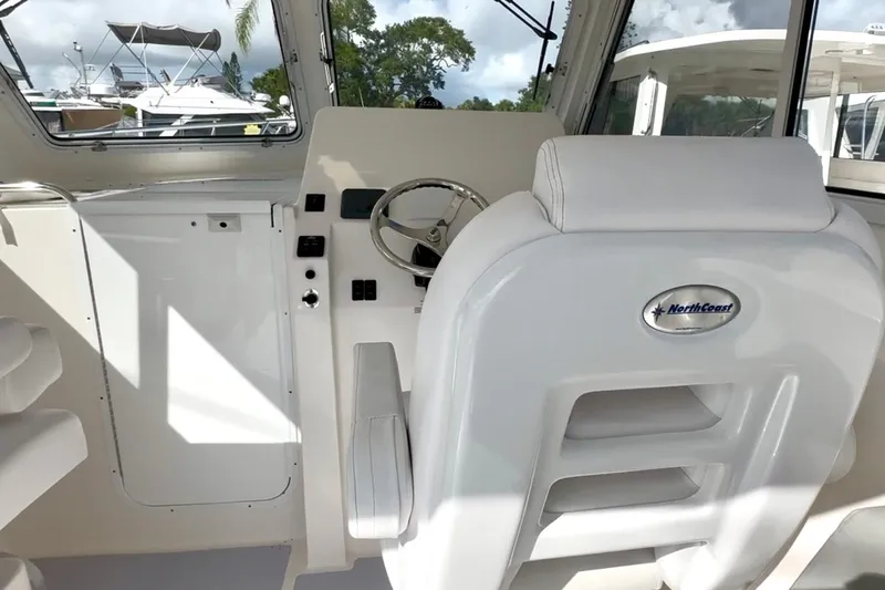 Slide: The Image of 2024 NorthCoast 255HT boat interior with steering wheel and captain's chair. - 16
