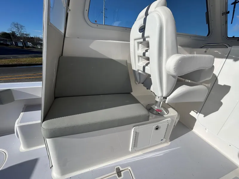 Slide: The Image of 2024 NorthCoast 255HT boat interior with cushioned seating and helm chair. - 18