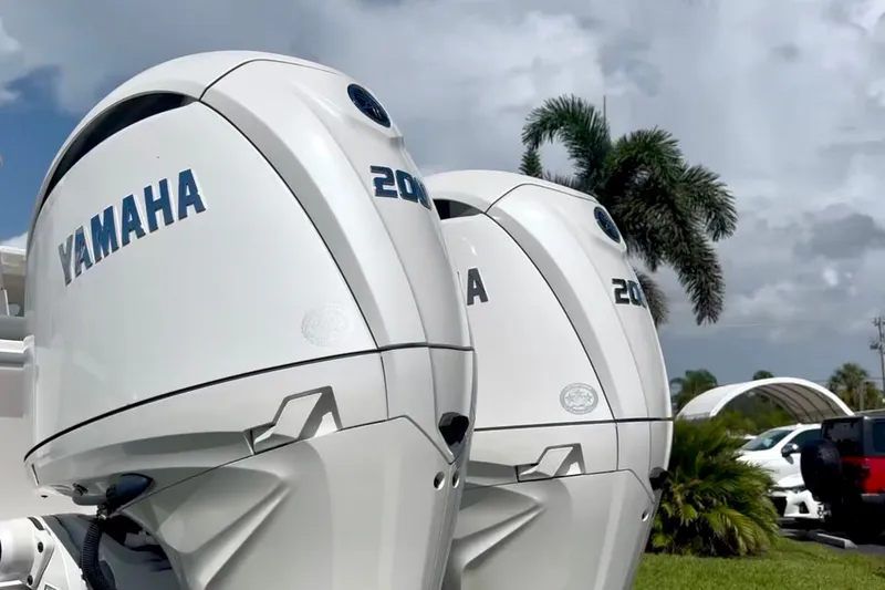 Slide: The Image of Yamaha 200 outboard motors on a 2024 NorthCoast 255HT boat, with palm trees in the background. - 2
