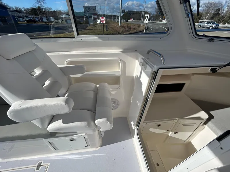 Slide: The Image of 2024 NorthCoast 255HT interior with white seating and cabin storage. - 28