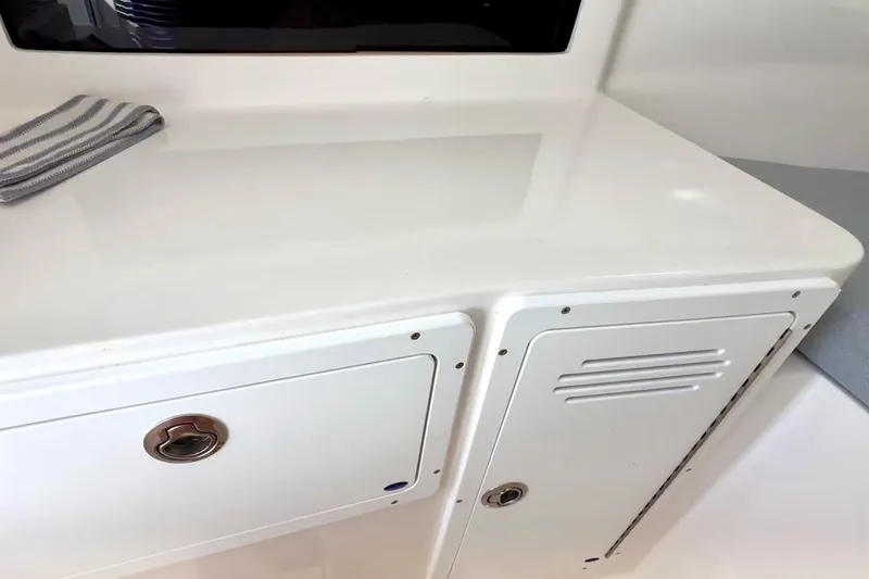 Slide: The Image of 2024 NorthCoast 255HT boat interior with white cabinetry and striped cloth. - 30