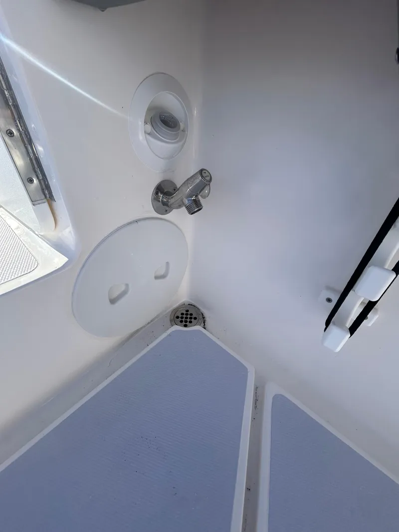 Slide: The Image of 2024 NorthCoast 255HT boat interior, featuring a compact shower area with drain and faucet. - 37