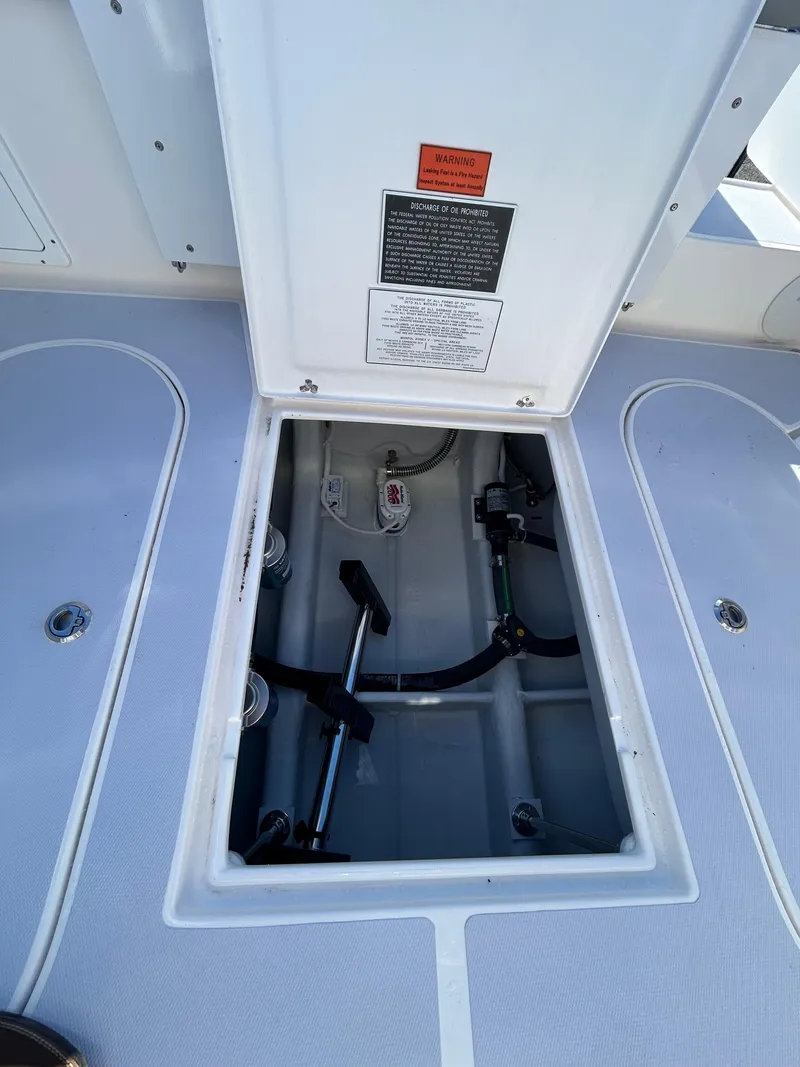 Slide: The Image of Open hatch of 2024 NorthCoast 255HT boat showing internal components and warning label. - 39