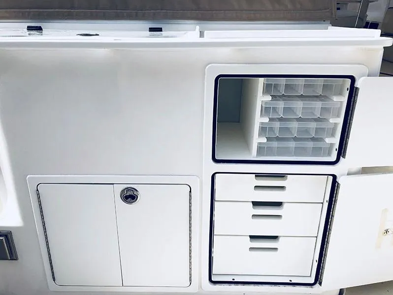Slide: The Image of 2024 NorthCoast 285HT boat storage compartments with drawers and tackle boxes. - 11