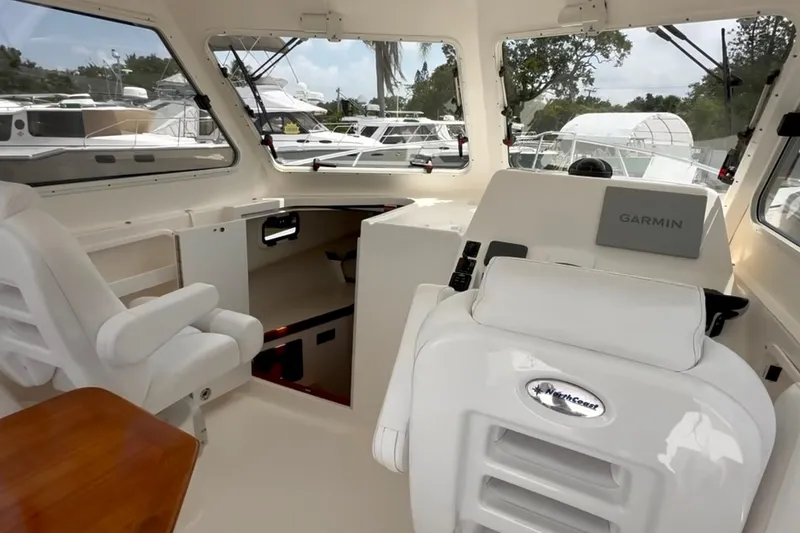 Slide: The Image of 2024 NorthCoast 285HT boat interior with Garmin navigation system and comfortable seating. - 16