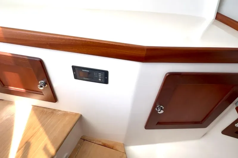 Slide: The Image of 2024 NorthCoast 285HT interior with wooden cabinets and control panel. - 25