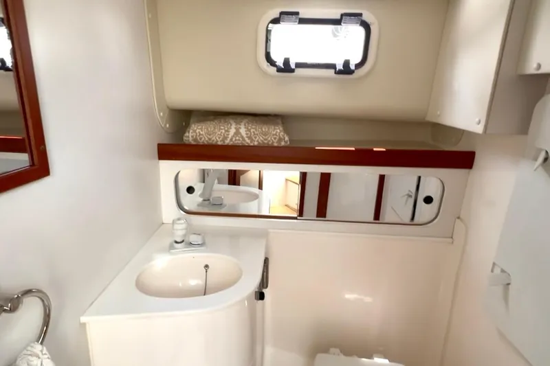 Slide: The Image of 2024 NorthCoast 285HT boat bathroom with sink, mirror, and storage cabinet. - 26