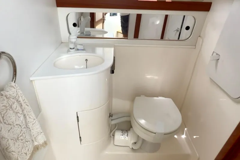 Slide: The Image of 2024 NorthCoast 285HT boat bathroom with sink, mirror, and toilet. - 27