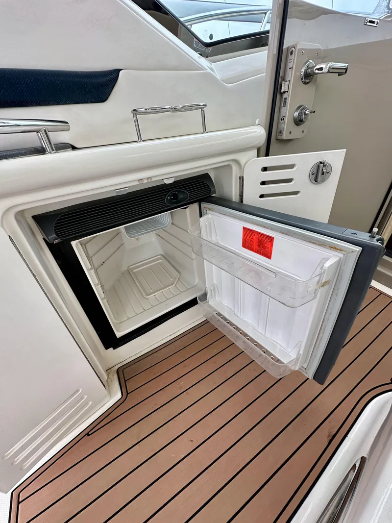 Slide: The Image of Open mini fridge on 2006 Sea Ray 44 Sundancer yacht, showcasing interior and deck flooring. - 16
