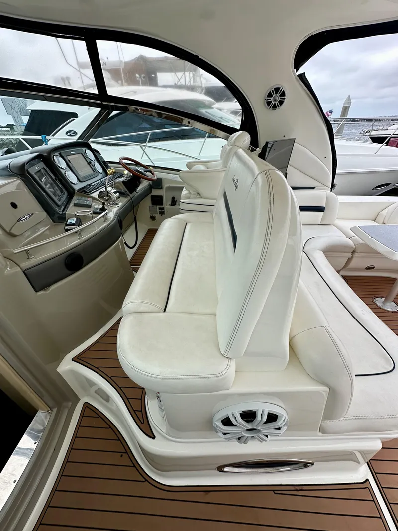 Slide: The Image of 2006 Sea Ray 44 Sundancer cockpit with white seating and modern dashboard. - 18