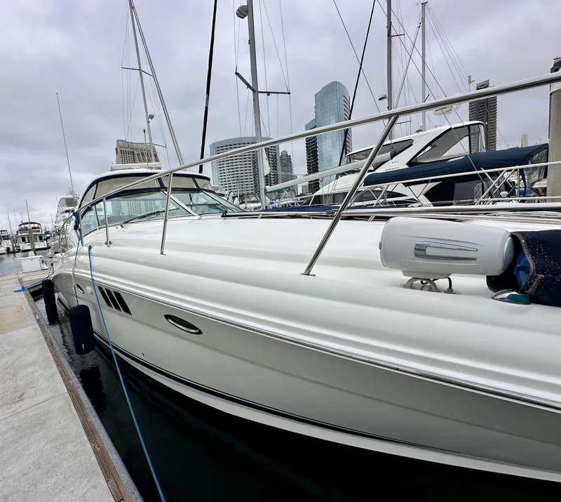 Slide: The Image of 2006 Sea Ray 44 Sundancer yacht docked at marina, city skyline in background. - 2