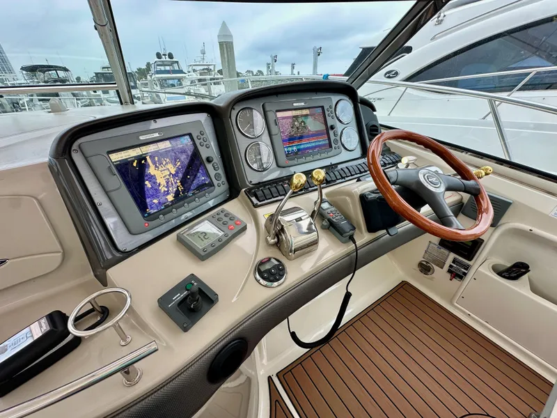 Slide: The Image of Helm of 2006 Sea Ray 44 Sundancer with navigation screens and wooden steering wheel. - 20