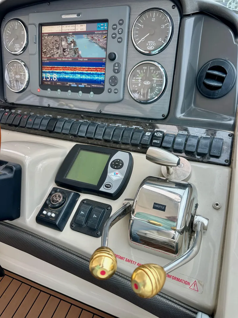 Slide: The Image of Control panel of a 2006 Sea Ray 44 Sundancer with navigation and throttle controls. - 23