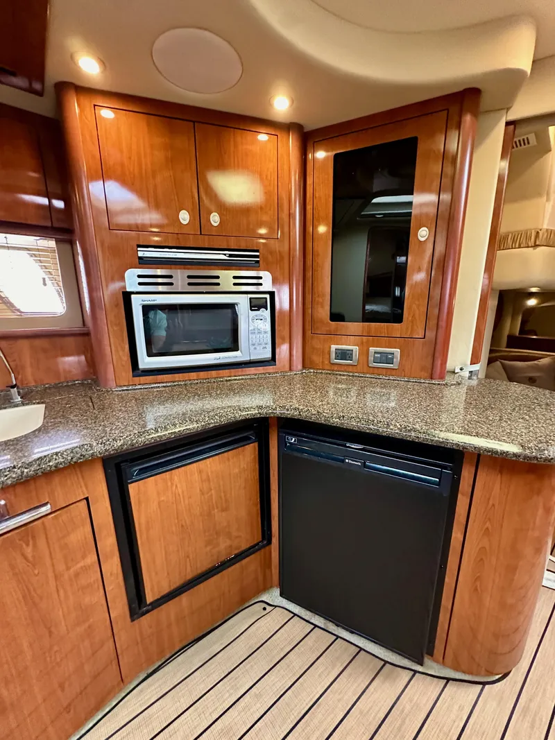 Slide: The Image of Luxurious 2006 Sea Ray 44 Sundancer yacht kitchen with wood cabinetry and modern appliances. - 38