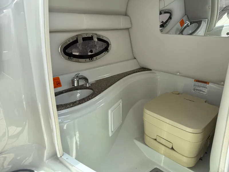 Slide: The Image of 2023 Crownline 250 XSS boat interior with sink and portable toilet. - 12