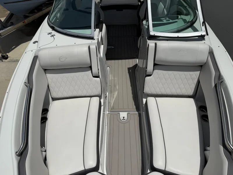 Slide: The Image of 2023 Crownline 250 XSS boat interior with white cushioned seating and open windshield. - 6