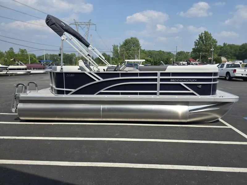 Slide: The Image of 2025 Bennington 20 SL pontoon boat parked in a lot, featuring sleek design and modern amenities. - 12