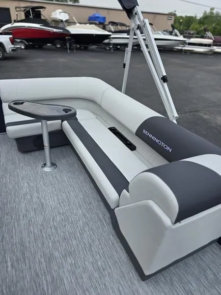 Slide: The Image of 2025 Bennington 20 SL boat interior with gray and white seating, table, and modern design. - 2