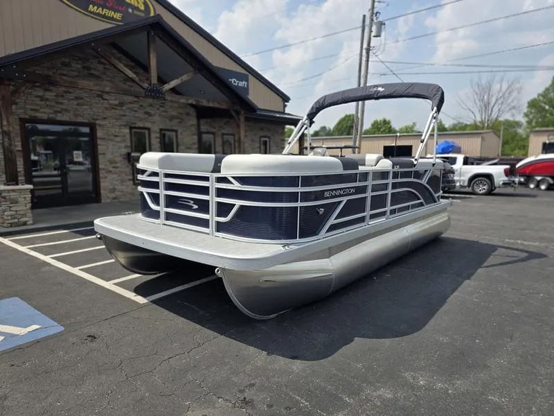 Slide: The Image of 2025 Bennington 20 SL pontoon boat parked outside a marine dealership. - 4
