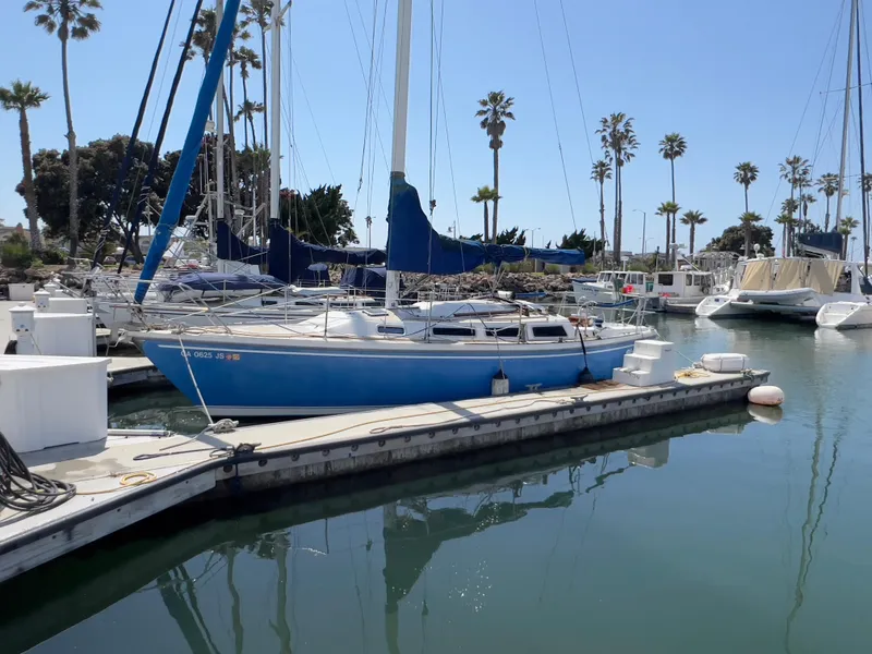 The Image of 1986 Catalina 30 sailboat docked in a marina with palm trees in the background. - 0