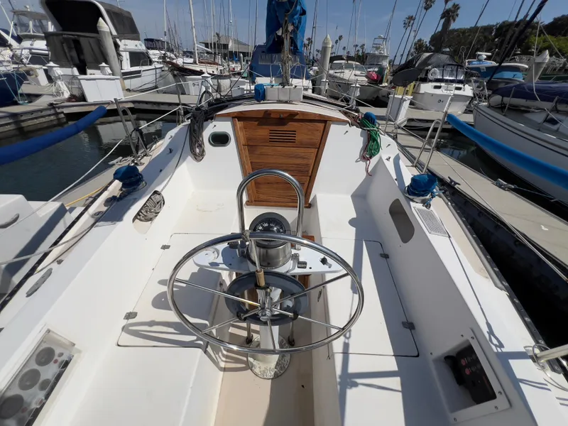 Slide: The Image of 1986 Catalina 30 sailboat cockpit with steering wheel, docked in marina. - 14