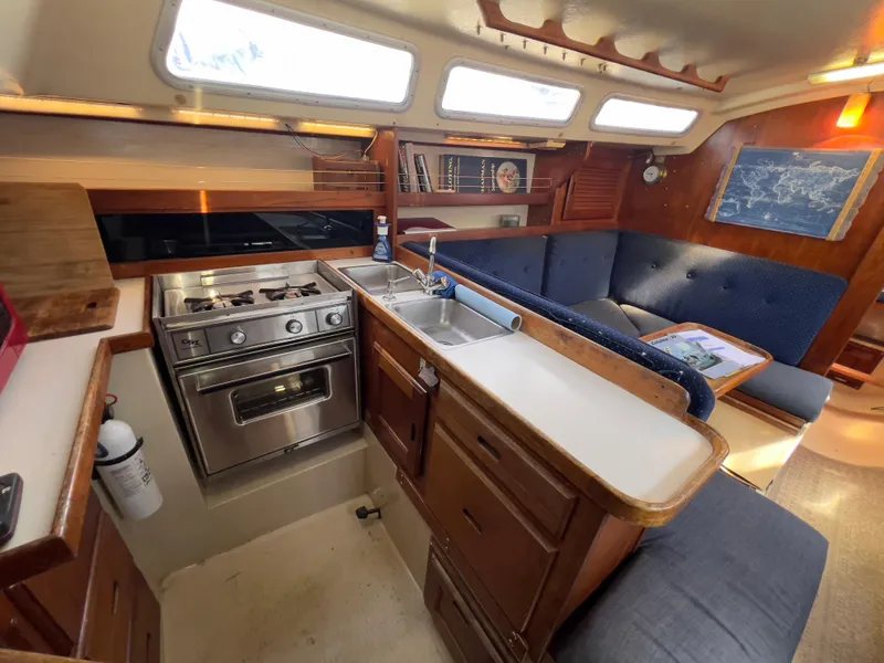 Slide: The Image of Interior of 1986 Catalina 30 sailboat with kitchen and seating area. - 17