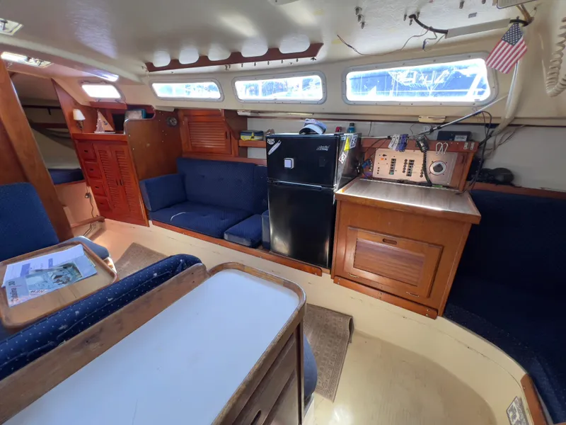Slide: The Image of Interior of a 1986 Catalina 30 sailboat with seating, fridge, and navigation equipment. - 19