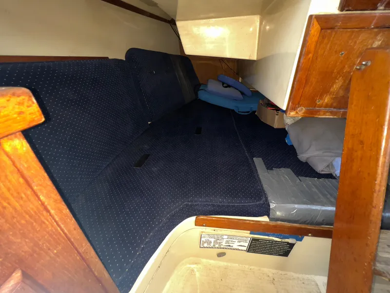 Slide: The Image of Interior cabin of a 1986 Catalina 30 sailboat with blue cushions and wooden accents. - 20